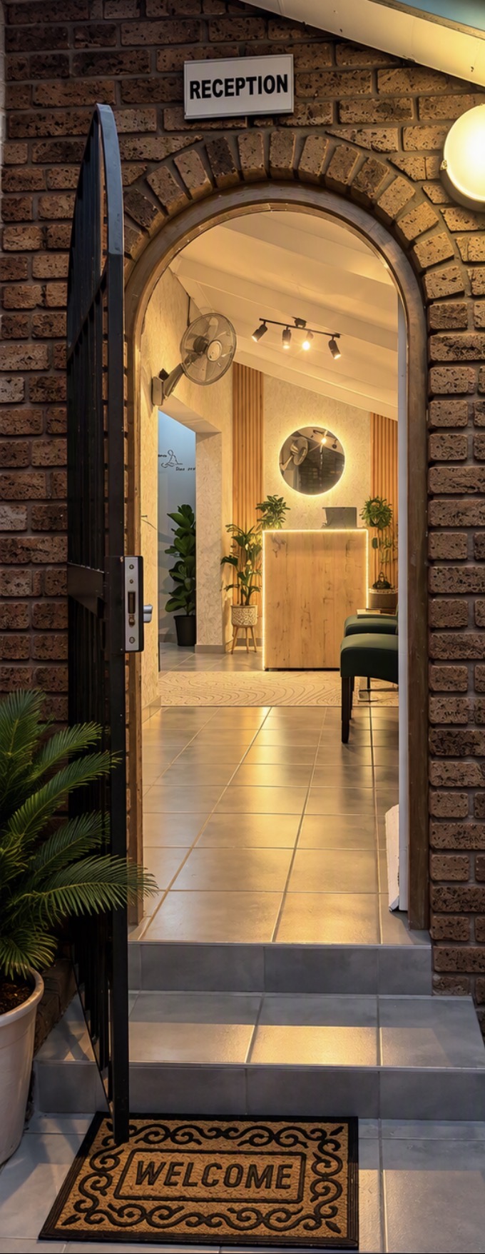 Arched brick entrance with a welcome mat leading into Massage Emporium reception